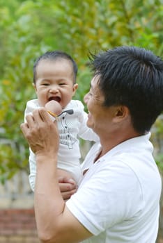Happy father's day! joyful young dad  hugging his cute son at outdoor park.