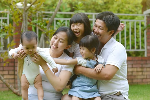 Portrait of happy asian family playing In garden.Concept of family relaxation.
