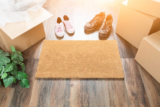Home Sweet Home Welcome Mat, Moving Boxes, Women and Male Shoes and Plant on Hard Wood Floors.