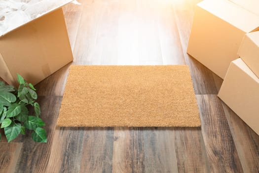 Blank Welcome Mat, Moving Boxes and Plant on Hard Wood Floors.