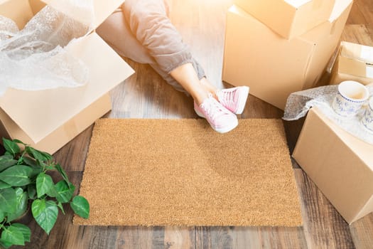 Woman Wearing Sweats Relaxing Near Home Sweet Home Welcome Mat, Moving Boxes and Plant.