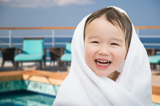 Happy Cute Mixed Race Chinese and Caucasian Boy On Cruise Ship Wrapped In A Towel.