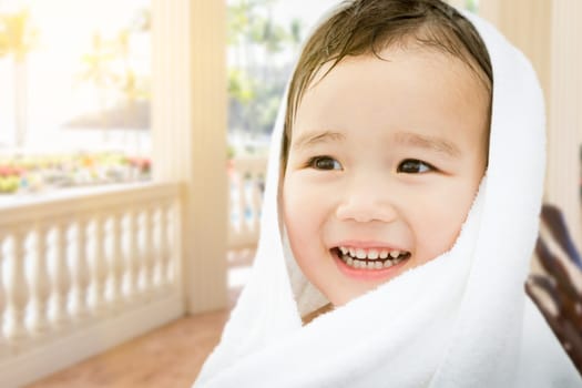 Happy Cute Mixed Race Chinese and Caucasian Boy On Tropical Patio Wrapped In A Towel.