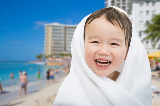 Happy Cute Mixed Race Chinese and Caucasian Boy On Waikiki Beach, Hawaii Wrapped In A Towel.