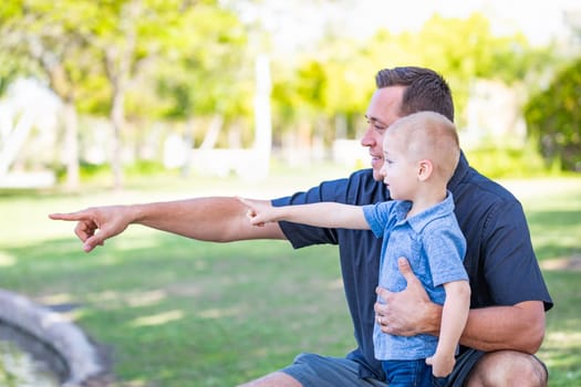 Young Caucasian Father and Son Having Fun At The Park.