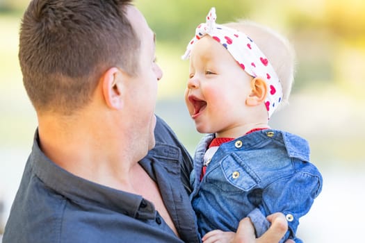 Young Caucasian Father and Baby Girl At The Park.