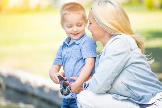 Young Caucasian Mother and Son Having Fun Fishing At The Lake.