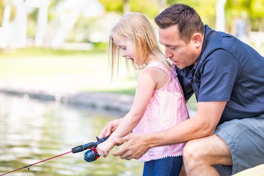 Young Caucasian Father and Daughter Having Fun Fishing At The Lake.