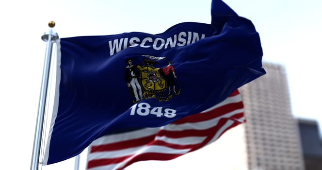 The flags of the Wisconsin state and United States waving in the wind. Democracy and independence. American state.
