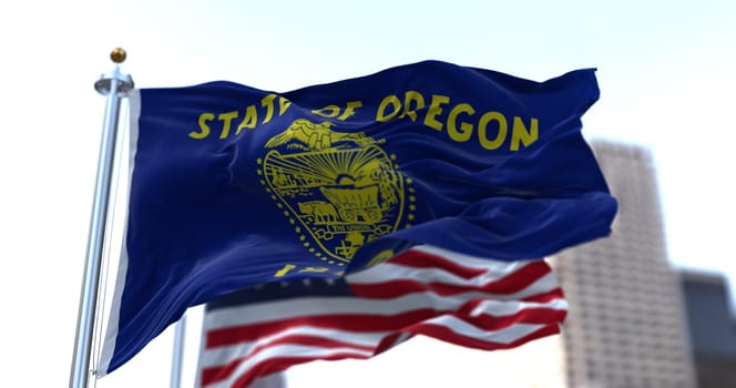 The flags of the Oregon state and United States waving in the wind. Democracy and independence. American state.
