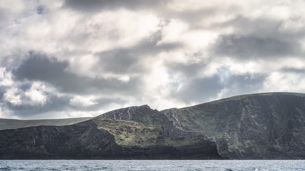 Beautiful tall Kerry Cliffs in morning light with dramatic sky, seen from boat on Atlantic Ocean, Portmagee, Iveragh Peninsula, Ring of Kerry, Ireland
