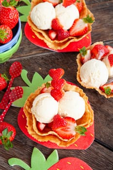 Vanilla ice cream with fresh strawberries in waffle cups