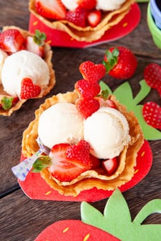 Vanilla ice cream with fresh strawberries in waffle cups