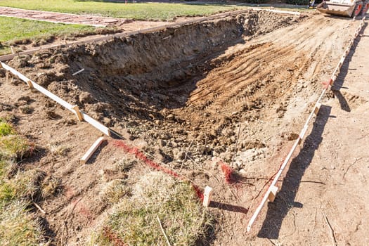 Freshly Dug Hole In Yard Preparing For Swimming Pool Installation.