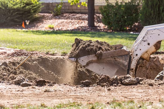 Small Bulldozer Digging In Yard For Pool Installation.