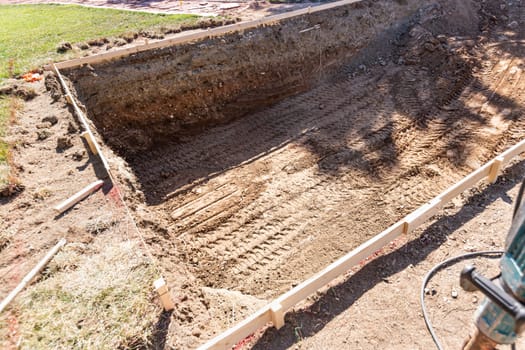 Freshly Dug Hole In Yard Preparing For Swimming Pool Installation.