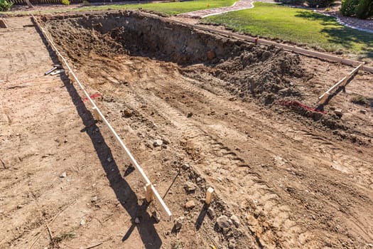 Freshly Dug Hole In Yard Preparing For Swimming Pool Installation.