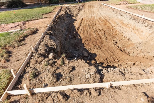 Freshly Dug Hole In Yard Preparing For Swimming Pool Installation.