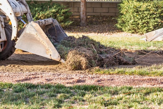 Small Bulldozer Removing Grass From Yard Preparing For Pool Installation.