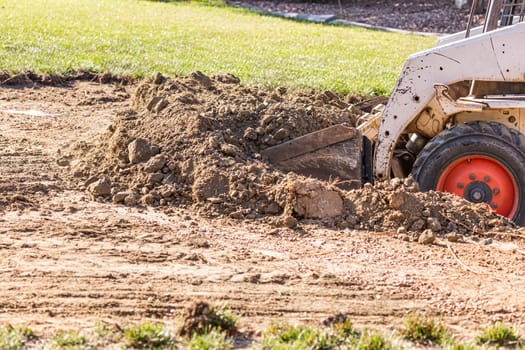 Small Bulldozer Digging In Yard For Pool Installation.