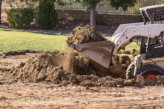 Small Bulldozer Digging In Yard For Pool Installation.