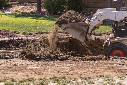 Small Bulldozer Digging In Yard For Pool Installation.