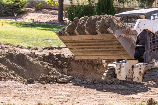 Small Bulldozer Digging In Yard For Pool Installation.