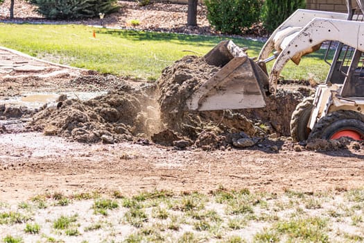 Small Bulldozer Digging In Yard For Pool Installation.