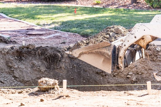 Small Bulldozer Digging In Yard For Pool Installation.