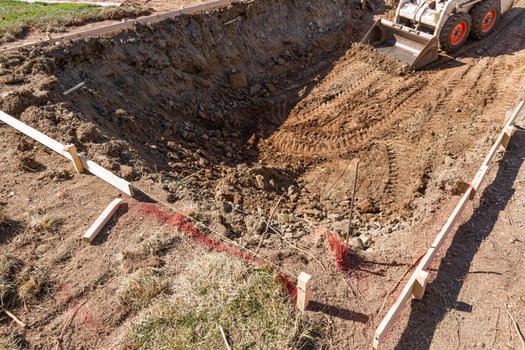 Small Bulldozer Digging In Yard For Pool Installation.