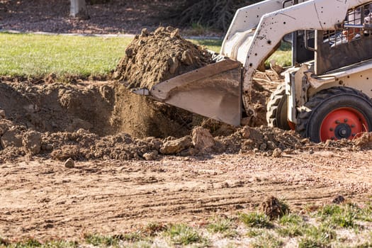Small Bulldozer Digging In Yard For Pool Installation.