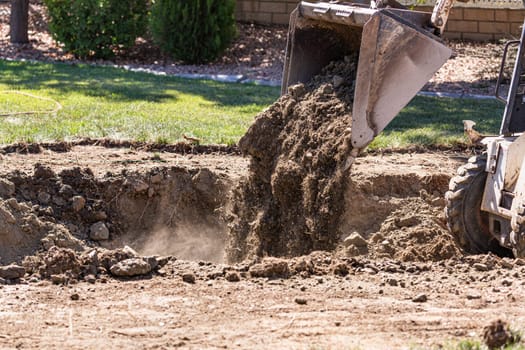 Small Bulldozer Digging In Yard For Pool Installation.