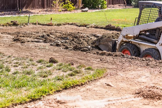 Small Bulldozer Digging In Yard For Pool Installation.