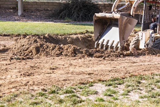 Small Bulldozer Digging In Yard For Pool Installation.