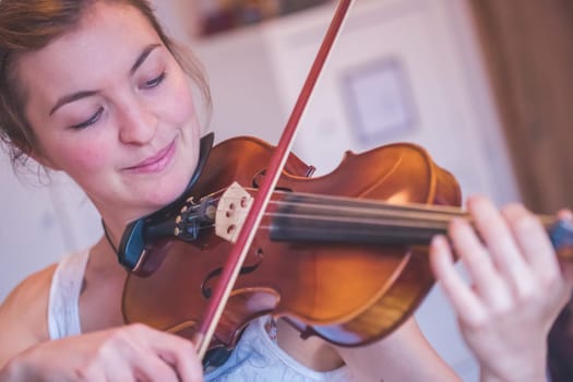 Pretty young girl practices on her violin, acoustic music