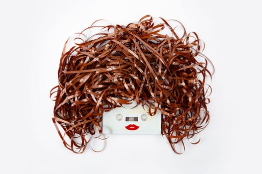 Conceptual female face with audio tape over bright background