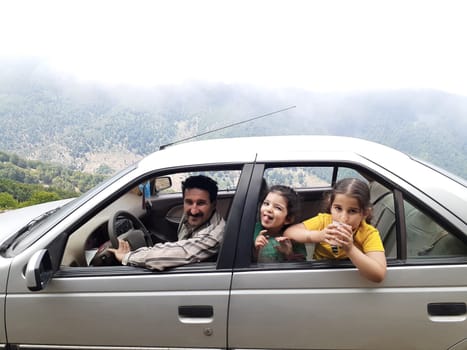 Young happy family in car-outdoor travel concept