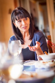 Pretty Italian Woman Enjoys A Meal And Drinks with Friends at Outdoor Restaurant.