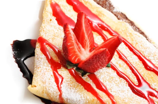 Decorative pancake with strawberry and chocolate syrup