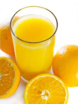 closeup orange juiceand few oranges on white