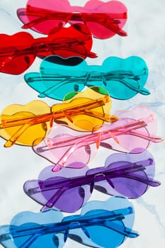 Colorful sunglasses in heart shaped on a blue background