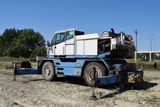 The disassembled loader crane. Old machinery repair.