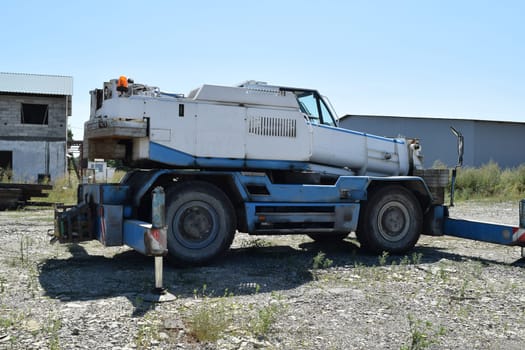 The disassembled loader crane. Old machinery repair.
