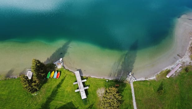 Aerial drone shot of swimming lake with colorful boats