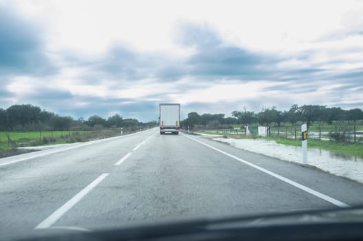 Driving behind a truck under persistent drizzle. Bad-weather driving concept