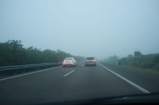 Car overtaking with heavy fog. Bad-weather driving concept