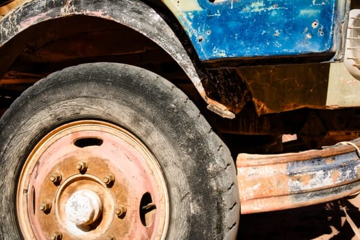 Grunge style shot of deteriorated and outworn front tire of an old truck. Close-up and detail.