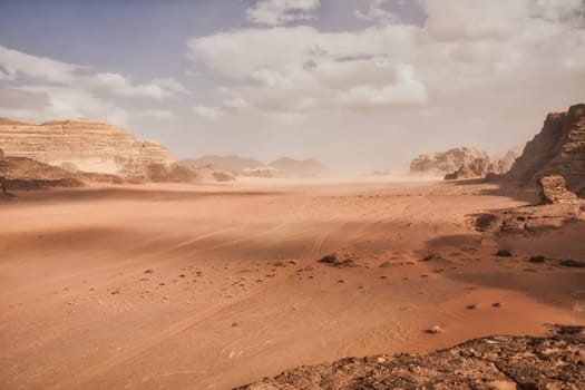 Dramatic desert landscape at Wadi Rum in Jordan with clouds rolling in through the valley. Travel and tourism