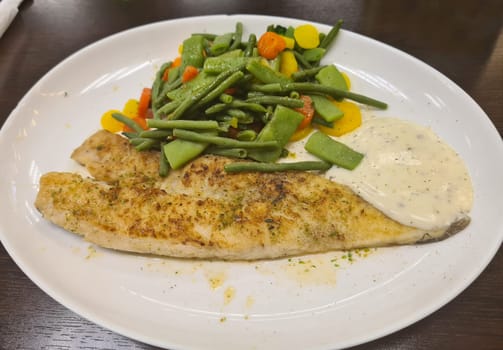 Fried fish on green asparagus with salad