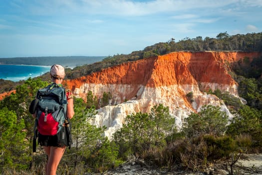 A woman traveller takes in the views of the amazing Pinnacles formation – a spectacular erosion feature that consists of cliffs of soft white sands capped with a layer of red gravel clay. It was deposited during the Tertiary geological period about 65 million years ago.